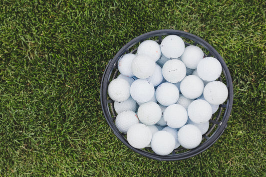 Range emmer met golfballen op een grasveld